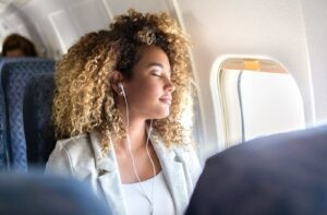 Sử dụng tai nghe để ngăn tiếng ồn và cố gắng thư giãn trên máy bay giúp giảm thiểu jet lag
